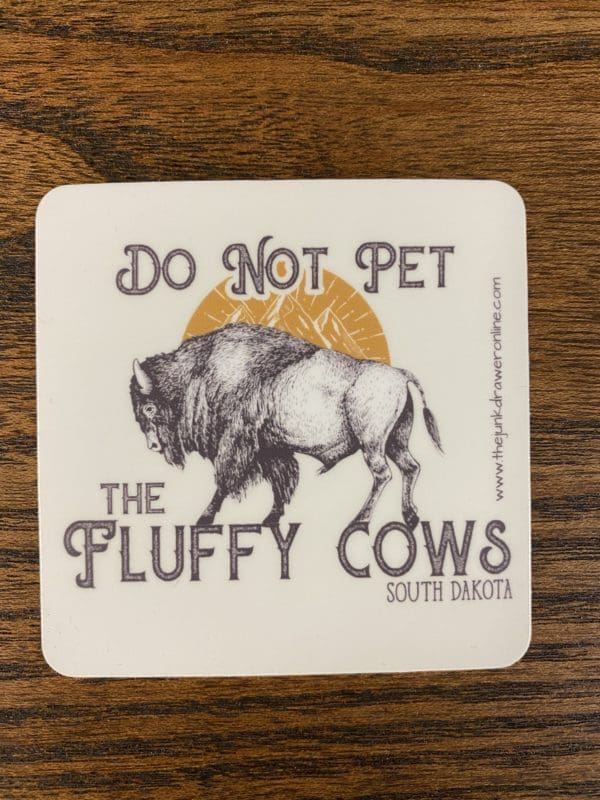 Do Not Pet the Fluffy Cows South Dakota sticker with a buffalo with the sun and hills being it design