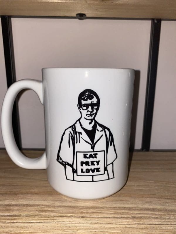 Custom mug with a drawn image of Jeffery Dahmer wearing a Eat Prey Love sign